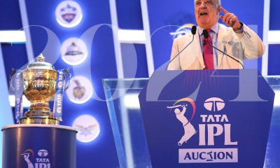 Image of IPL auction anchor and IPL trophy on display